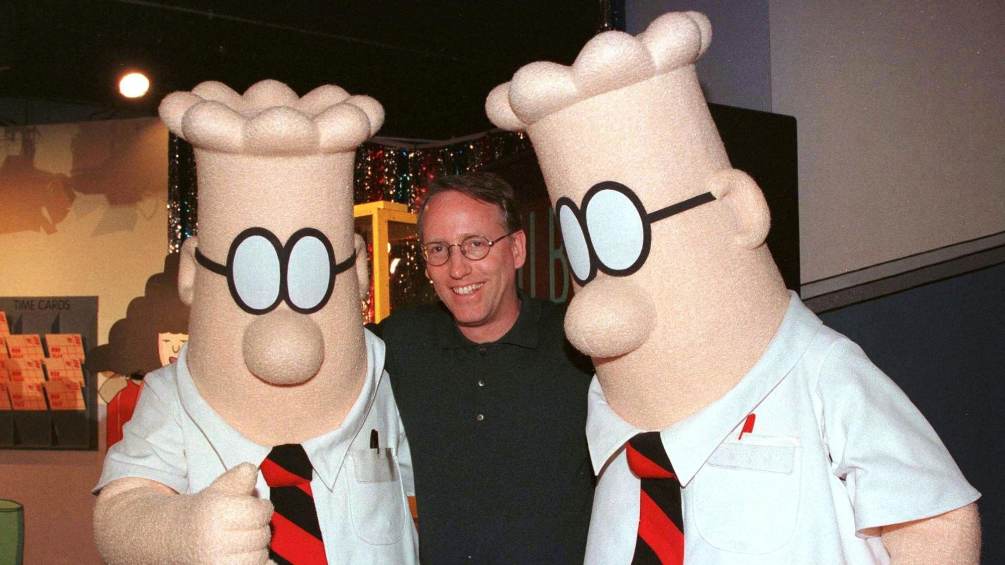 Scott Adams, junto a dos muñecos que representan a su personaje Dilbert .