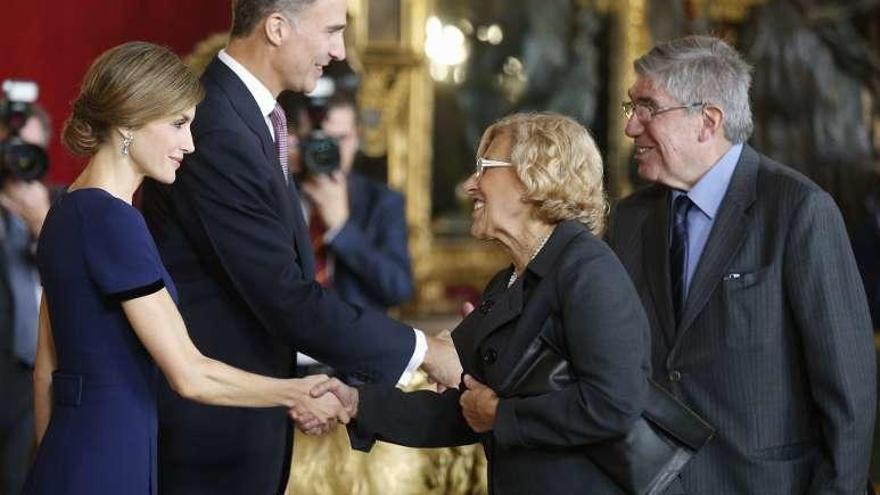 La alcaldesa de Madrid, Manuela Carmena, estrecha la mano de la Reina.