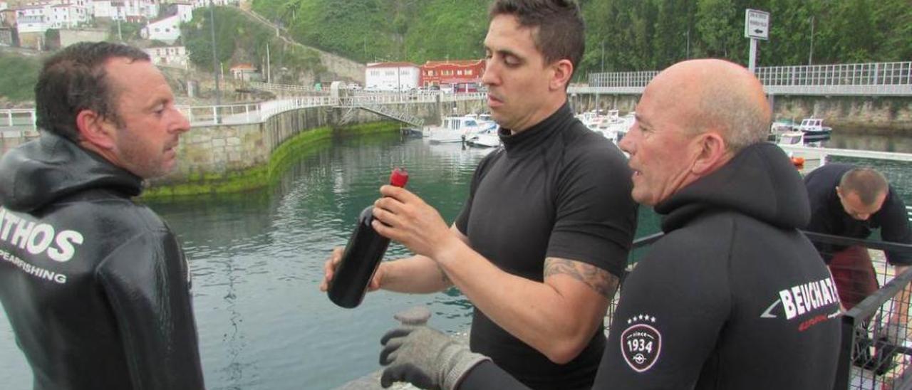 Jesús Gallego, Javier Domínguez y Rafael Menéndez, con la única botella recuperada.