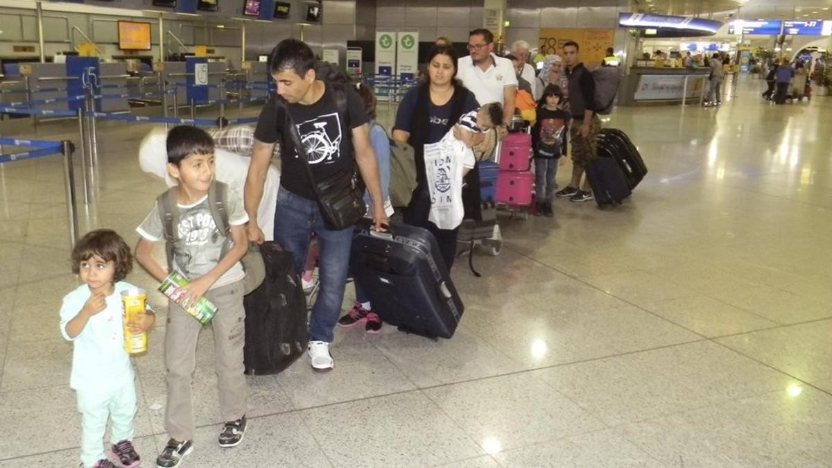 Los primeros refugiados procedentes de Grecia de origen sirio e iraquí acogidos en España, en la cola de facturación en el aeropuerto de Atenas, antes de partir hacia Madrid, el 24 de mayo del 2016.