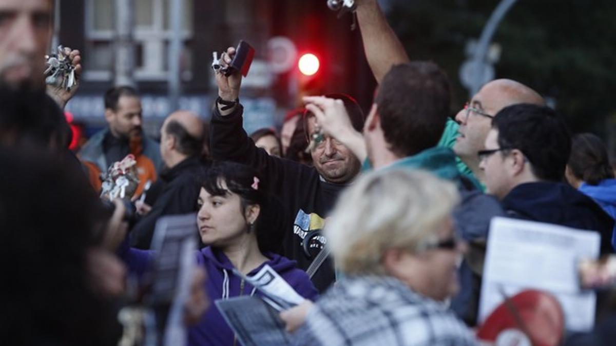 Varios vecinos agitan sus llaveros durante la protesta en la plaza de Sants, este viernes.