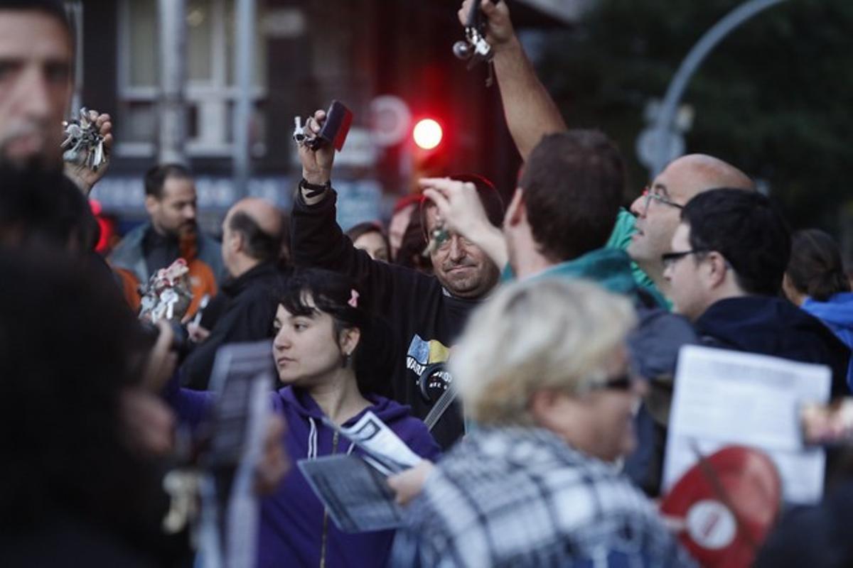 Varios vecinos agitan sus llaveros durante la protesta en la plaza de Sants, este viernes.
