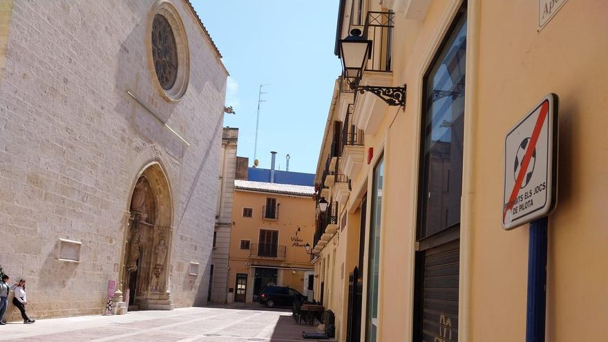 La plaza del Apòstols, con la Colegiata a la izquierda y el cartel que prohíbe juegos de pelota a la derecha.