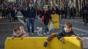 Creu Coberta, eje comercial de Sants, un sábado de diciembre, repleta de gente andando por el asfalto en ausencia de coches.