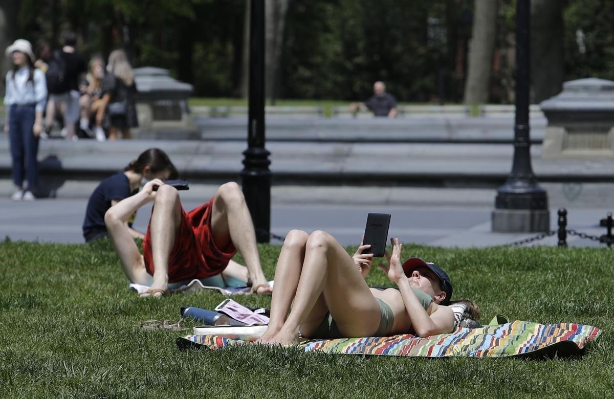 Jóvenes disfrutan del clima cálido en Washington Square Park, durante la pandemia.