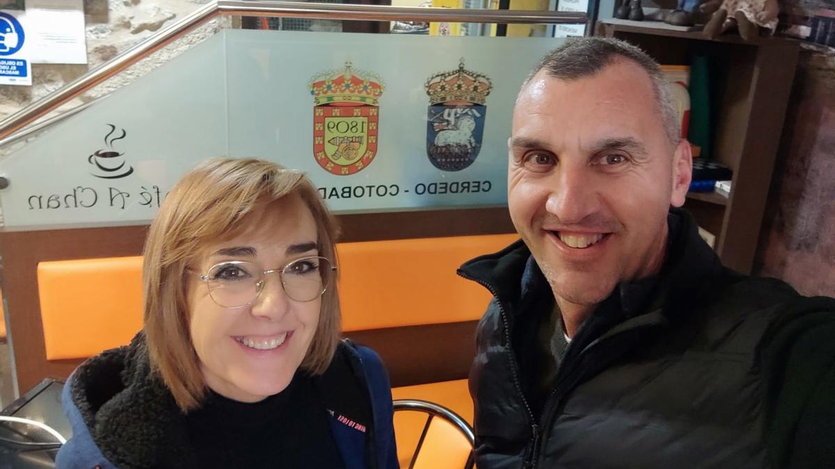 Yolanda y Casiano, en su cafetería junto a los escudos de Cotobade y Cerdedo.