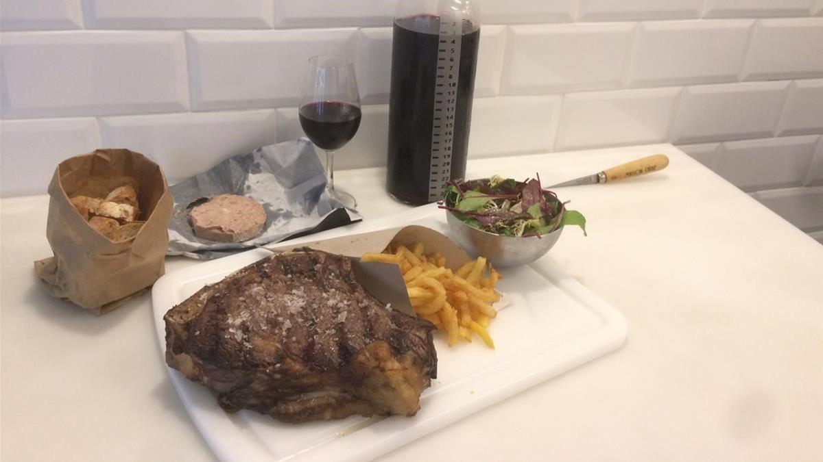 El chuletón, con patatas, ensalada y paté de hígado de cerdo, y el vino por centímetros.