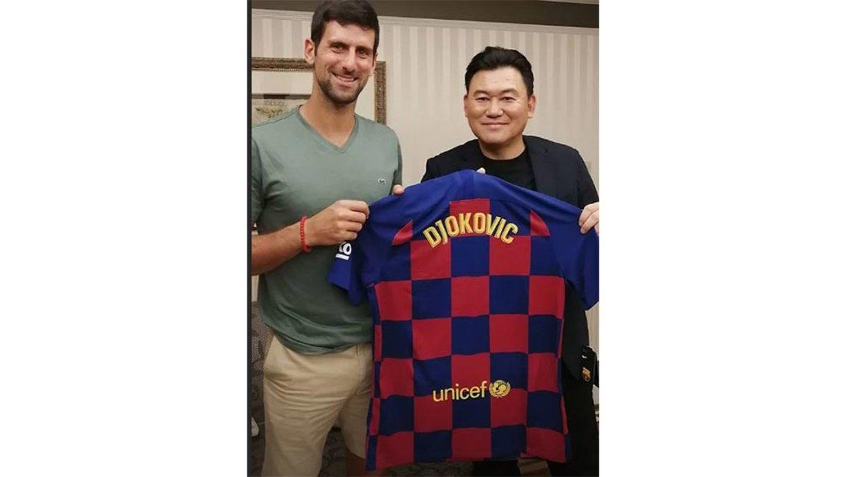 Djokovic y Mikitani posando con la camiseta del FC Barcelona