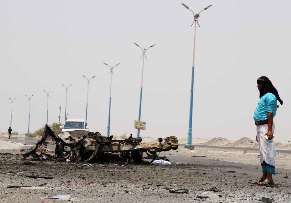 A man stands past the wreckage of government ...