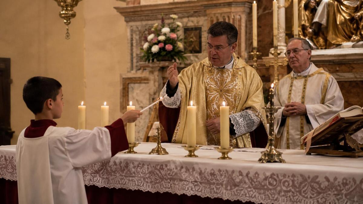 Un cura y un monaguillo durante una misa.