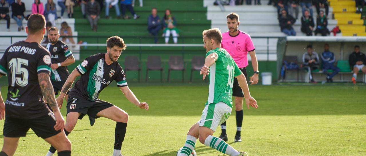 Colau (Cacereño) intenta colarse entre la defensa del Mérida.