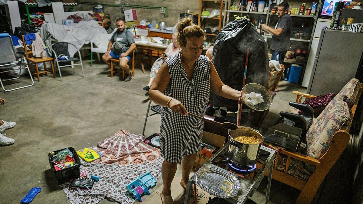 Jéssica Acosta prepara unas potas en salsa en el garaje dónde viven después de que ser desalojados de Todoque tras la erupción. | | ANDRÉS GUTIÉRREZ