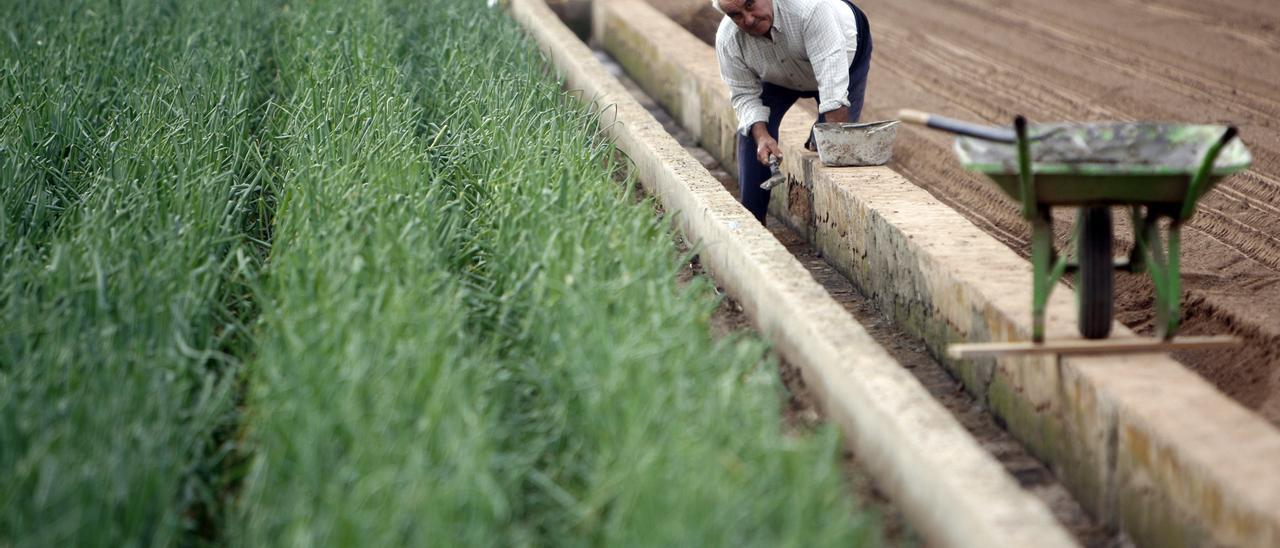 Un agricultor repara su acequia