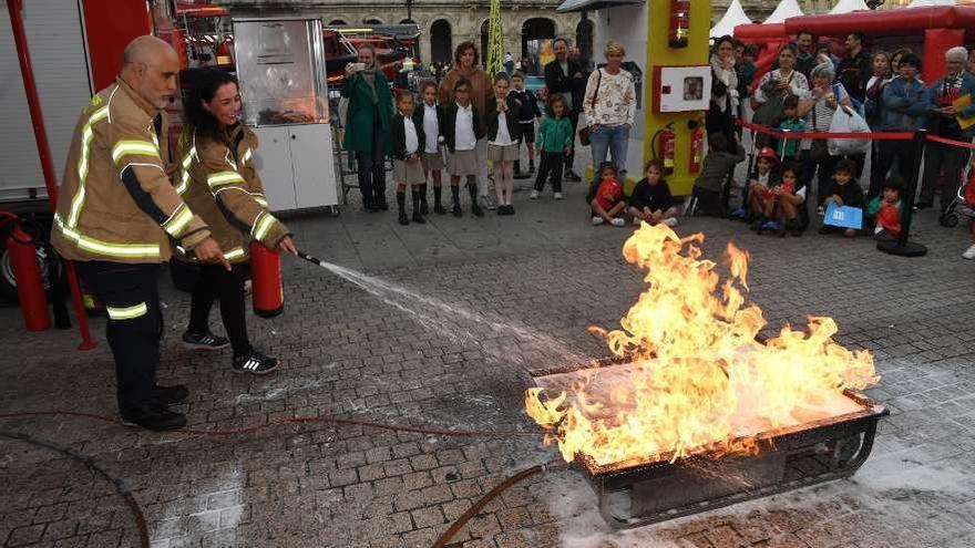 Los bomberos explican cómo apagar un fuego, ayer en María Pita.