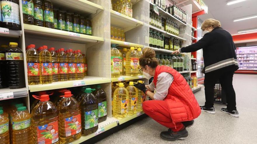 Una empleada repone aceites en un supermercado.