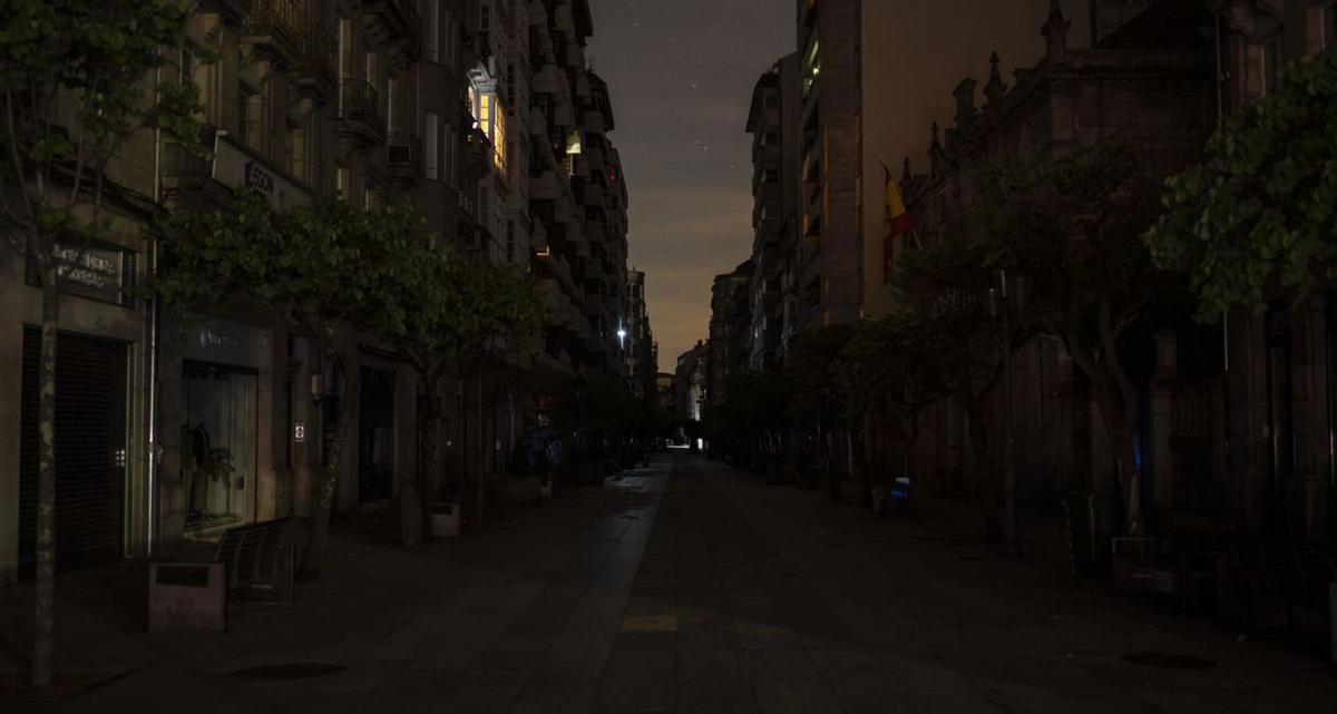 La calle del Paseo, la principal vía de Ourense, casi a oscuras al caer la noche. | Brais Lorenzo / EFE