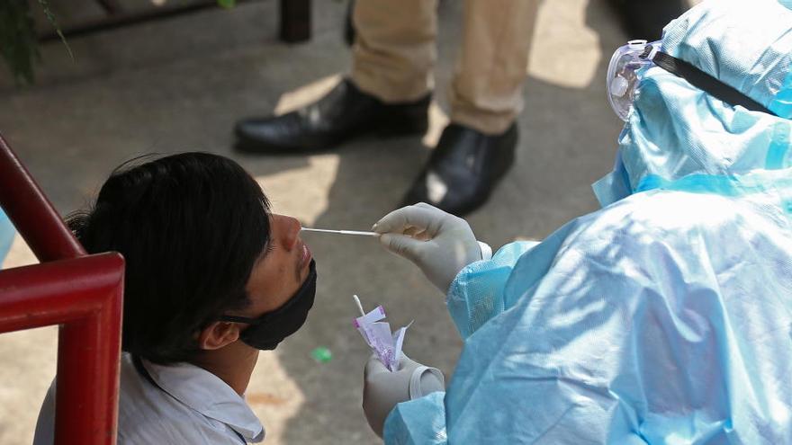 Un sanitario realiza un test de coronavirus a una persona en India.