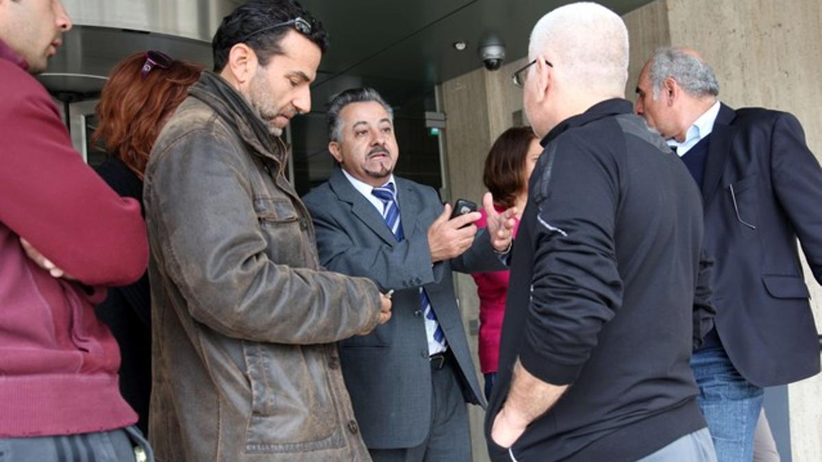 Un responsable de un banco (centro) habla con varios clientes, este sábado en Nicosia.