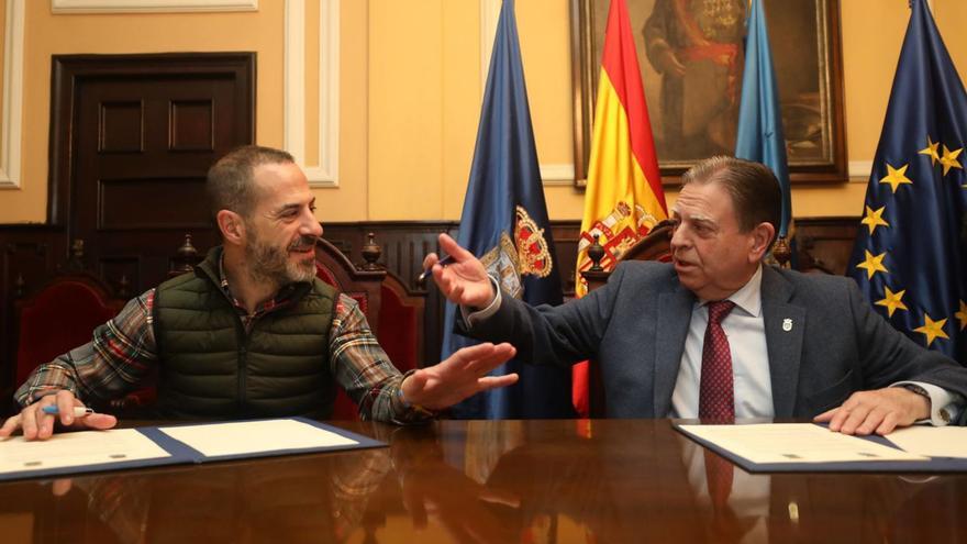 Ángel García, a la izquierda, y Alfredo Canteli, ayer, durante la firma de un convenio para prestar alumbrado público en zonas limítrofes entre ambos municipios.