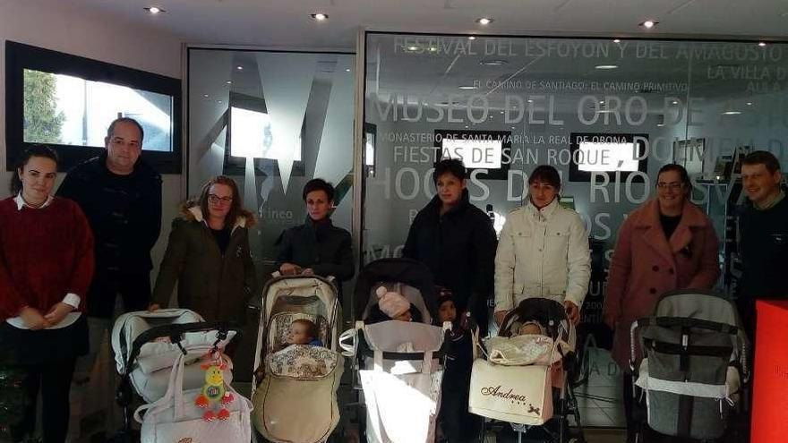 Las familias beneficiarias de la ayuda, con la edil Jennifer Fernández y el alcalde, José Ramón Feito, ambos en la mesa, durante la entrega de las ayudas, ayer, en Tineo.