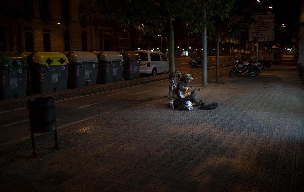 Kevin, 32 años. Este ciudadano francés toca la guitarra por las calles de Barcelona. ’Ahora toco solo para mí. No hay nadie en la calle’, explica.