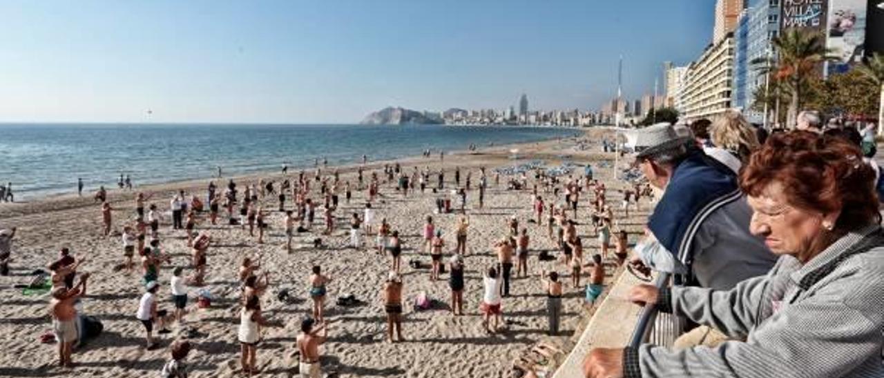 Personas de la tercera edad haciendo gimnasia en la playa de Benidorm.