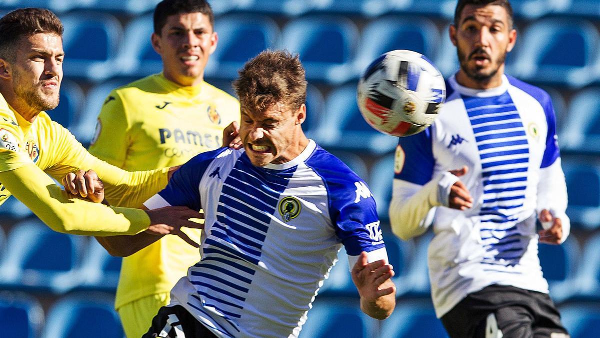 Tano despeja un balón en presencia de Moisés, los dos centrales titulares del Hércules, en el partido ante el Villarreal B.