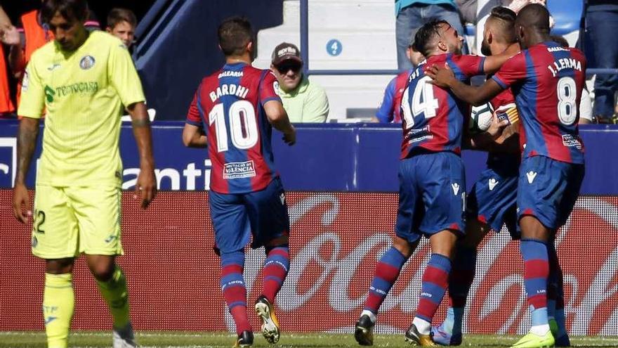 Los jugadores del Levante celebran el gol con un defensor del Getafe a la izquierda.