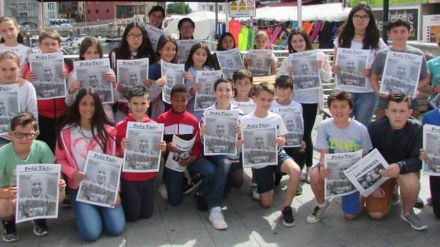 Escolares de sexto de Primaria del colegio Peña Tú en el puente de Llanes con el periódico, ayer.