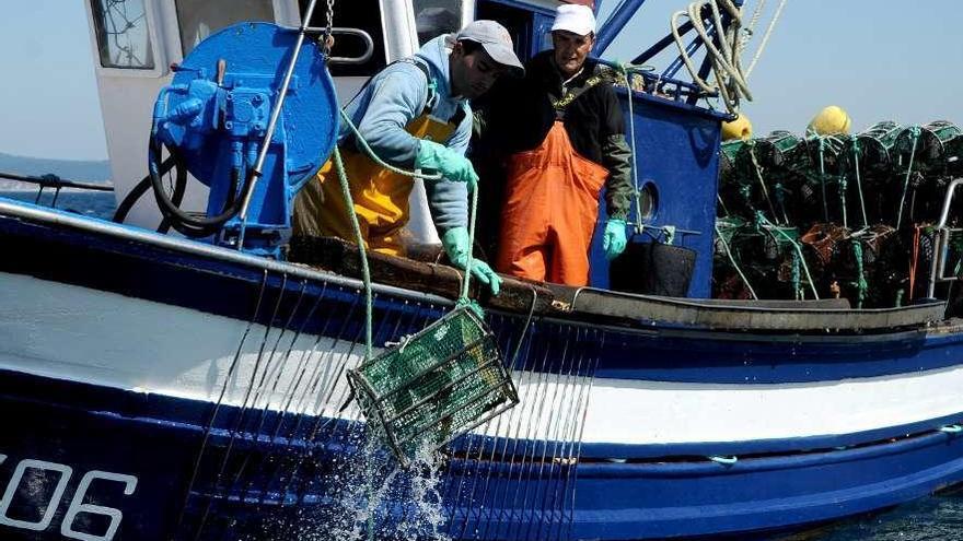 Dos marineros a bordo de un buque durante la campaña del pulpo.