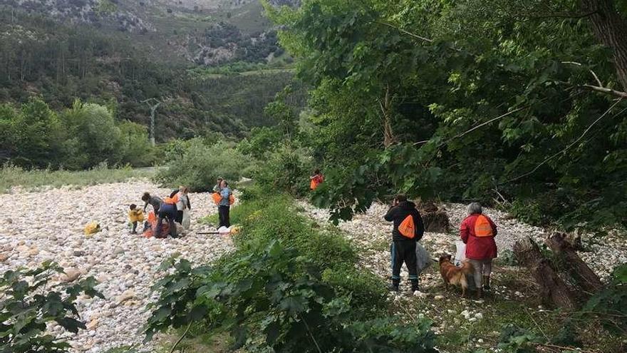 Los voluntarios limpian la zona del río en Panes.