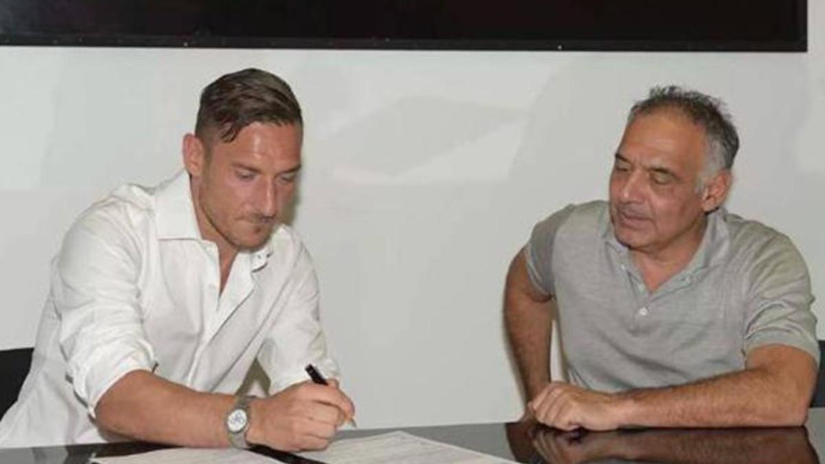 Totti firma la renovación de su contrato con la Roma en presencia del presidente del club, James Pallotta