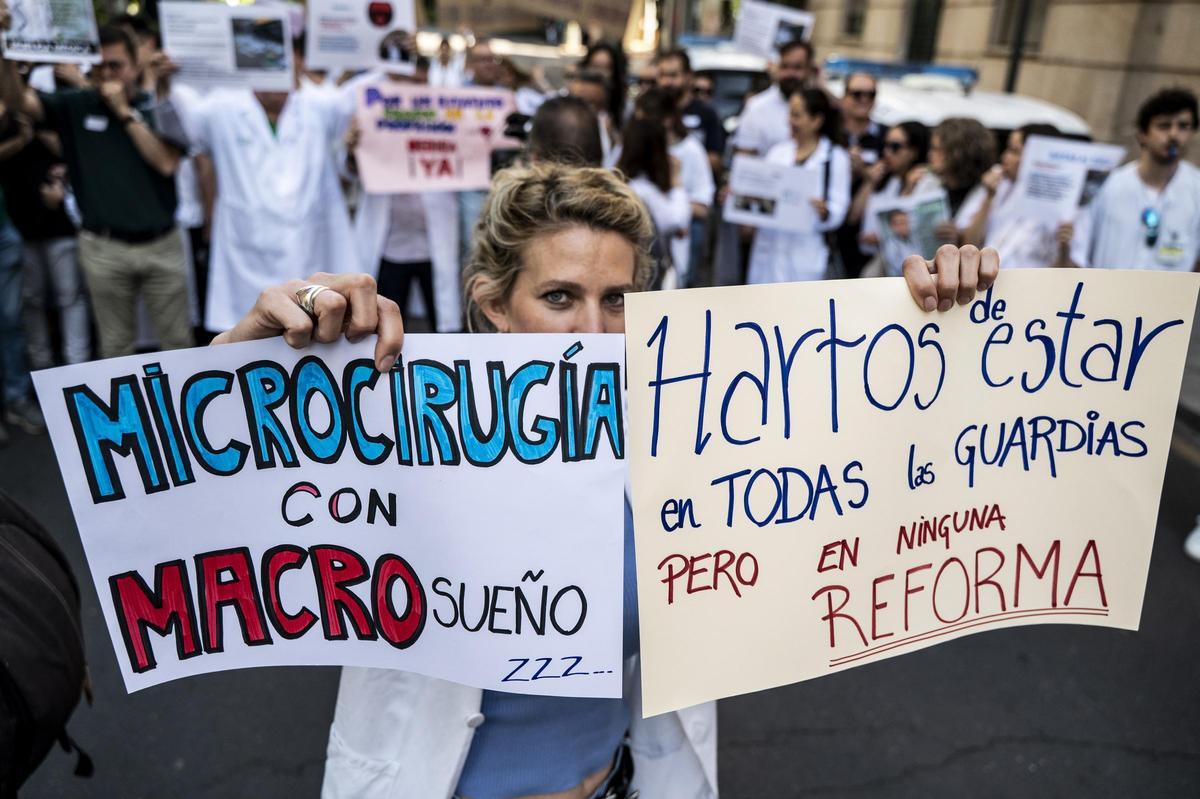 Una médica muestra dos carteles de protesta en una de las manifestaciones anteriores celebradas en Cáceres.