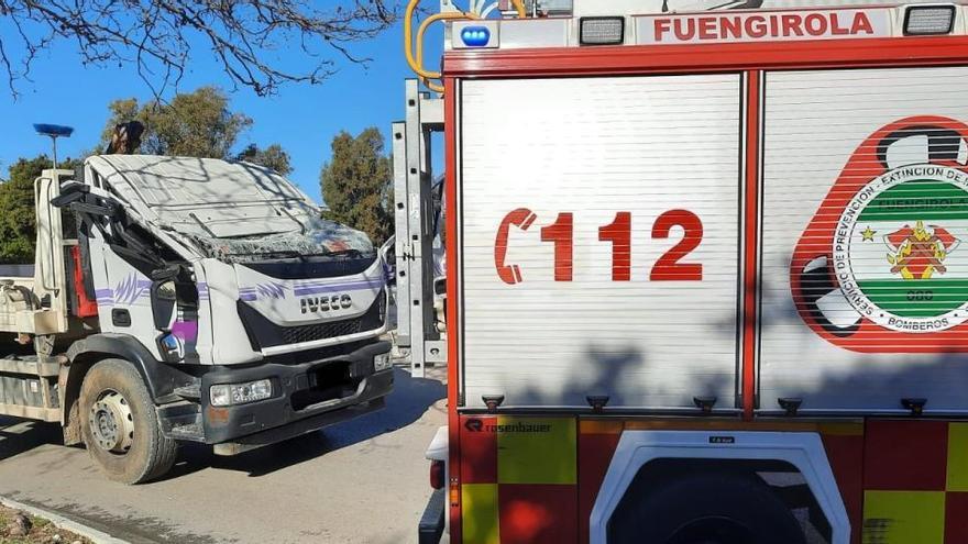 Estado en el que quedó el camión, junto a uno de los bomberos de Fuengirola.