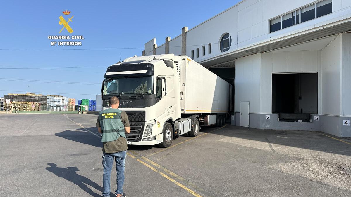 Un agente de la Guardia Civil ante un camión de transporte de mercancías