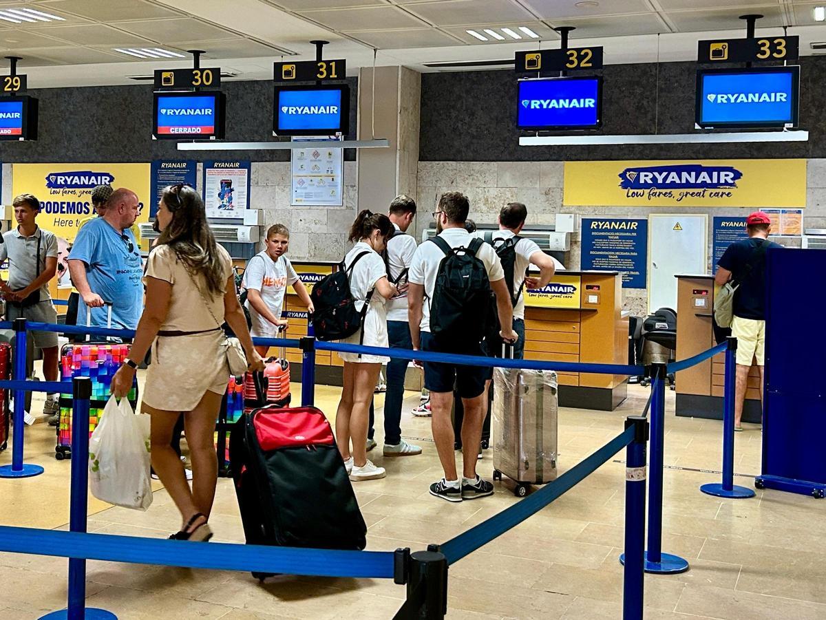 Passatgers esperant per facturar als taulells de Ryanair
