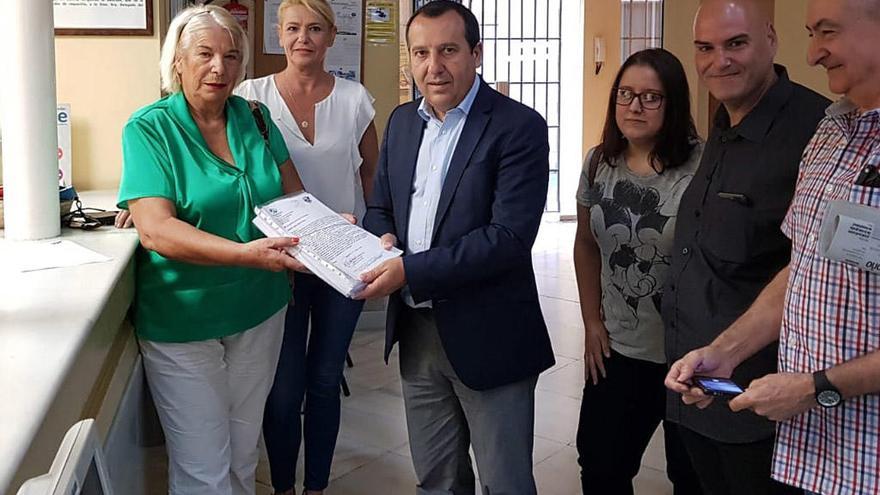 La presidenta de la asociación de vecinos de Campanillas, Carmela Fernández, entrega las más de 10.000 firmas al delegado de la Junta, José Luis Ruiz Espejo.