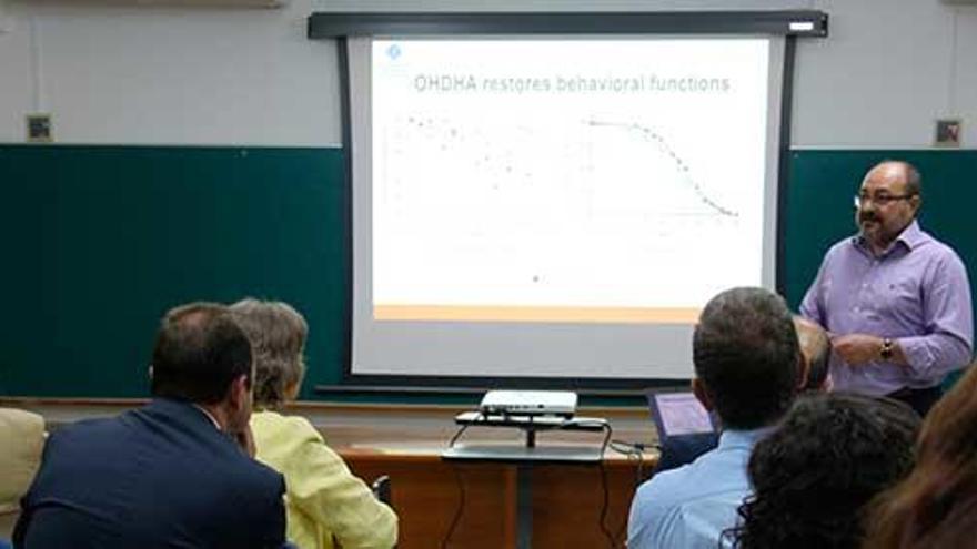 Pablo Escribá explicando sus avances con la molécula DHA-H, compomente del Dhalifort, con el rector Huguet en primera fila a la izquierda.