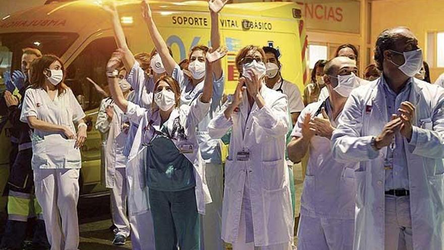 Personal sanitario sale al exterior de un hospital para aplaudir.