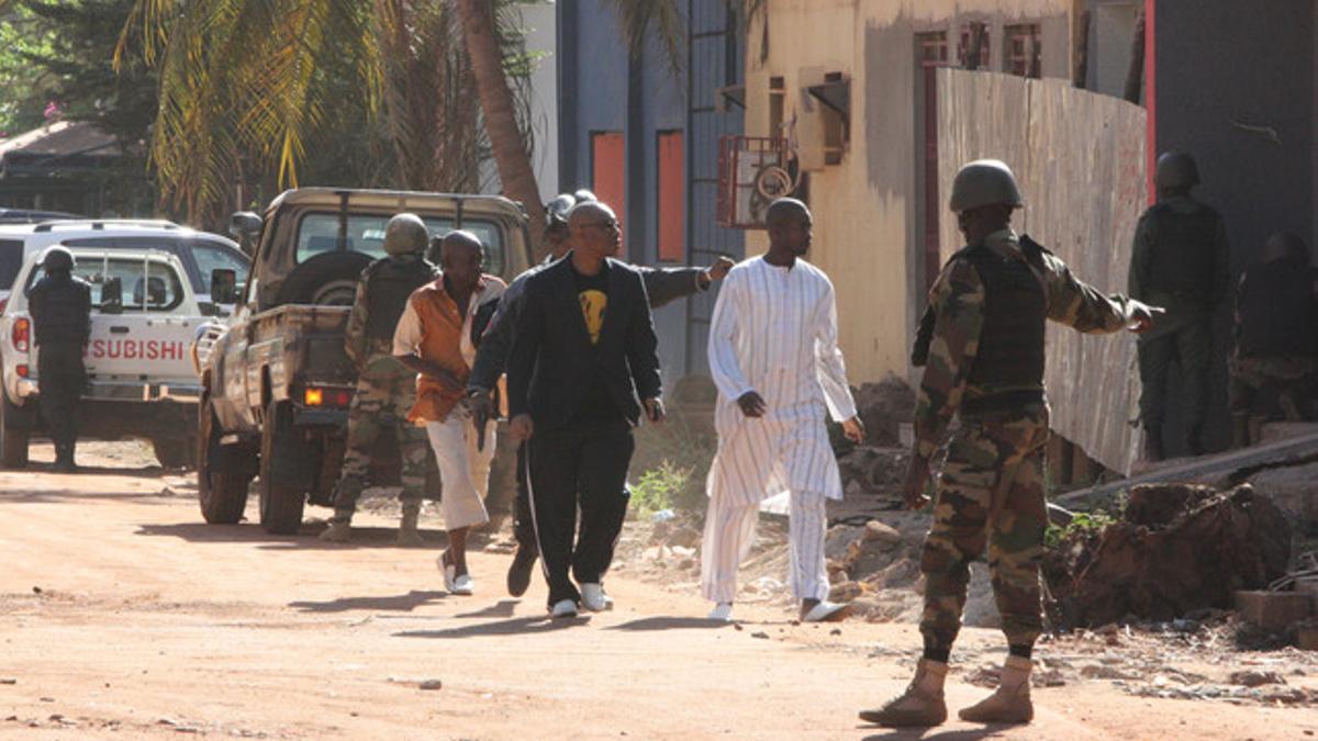 Fuerzas de seguridad escoltan algunas personas que han podido salir del hotel Radisson de Bamako.