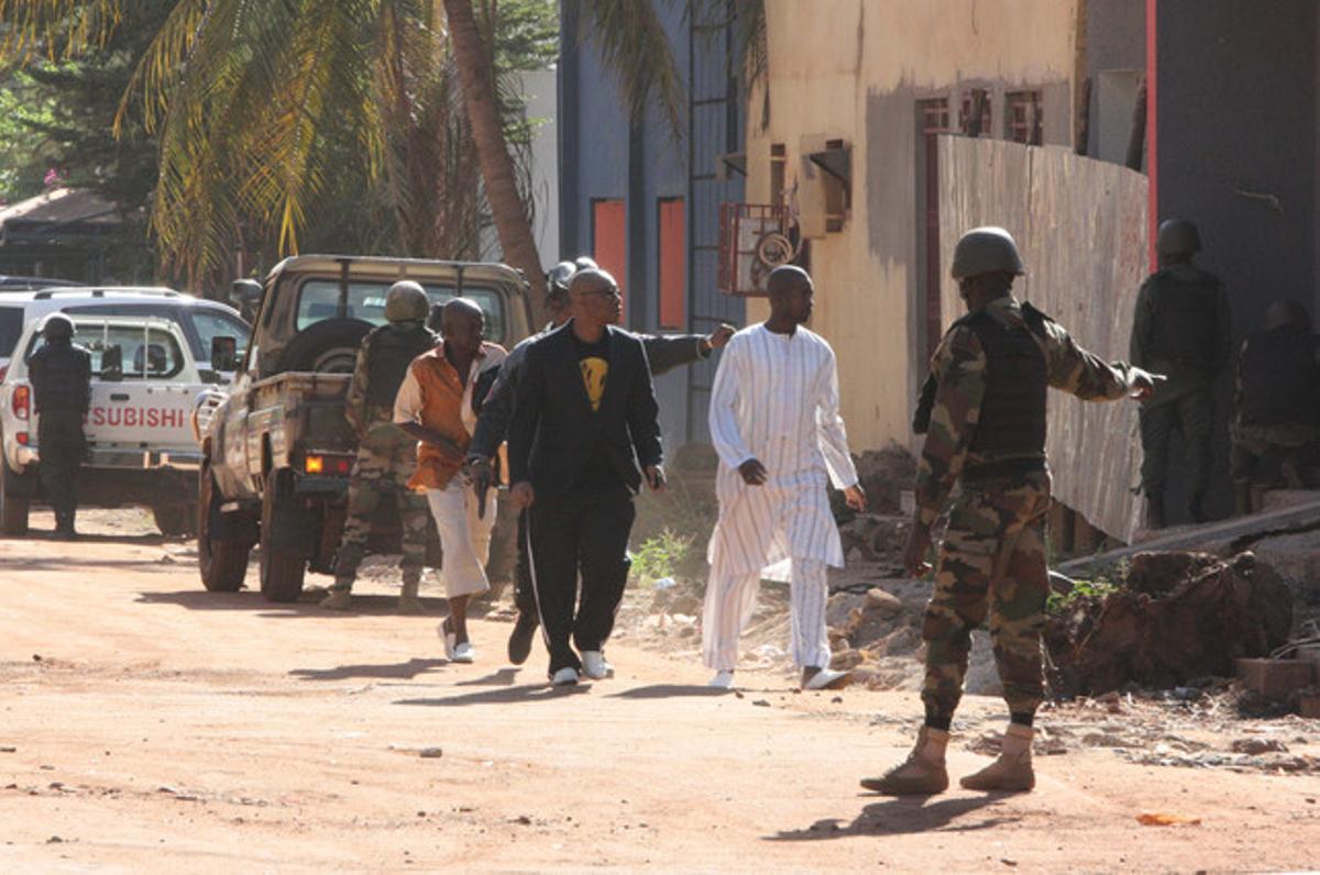 Forces de seguretat escorten algunes persones que han pogut sortir de l’hotel Radisson de Bamako.