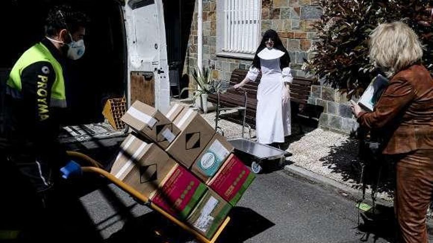 Sor Francisca Arredondo recibe a Viorica Musatovi, de la comunidad judía en Asturias, y a un repartidor, a su llegada a la residencia de las Hermanitas de los Ancianos Desamparados con material sanitario.