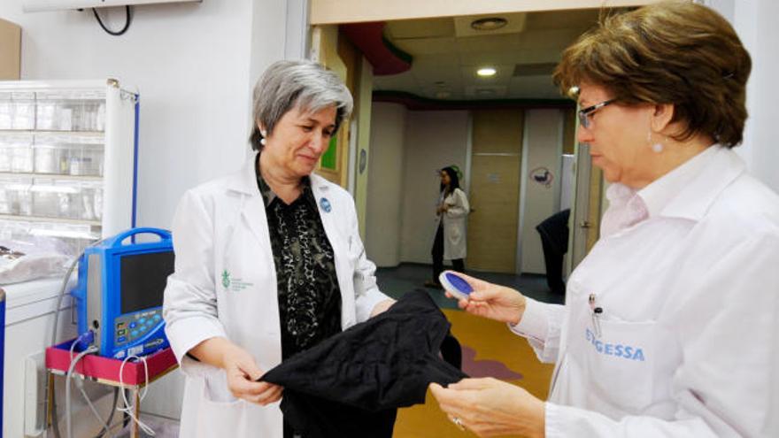 La doctora Empar Lurbe sostiene una camiseta y la doctora Isabel Torró lleva el cronómetro.