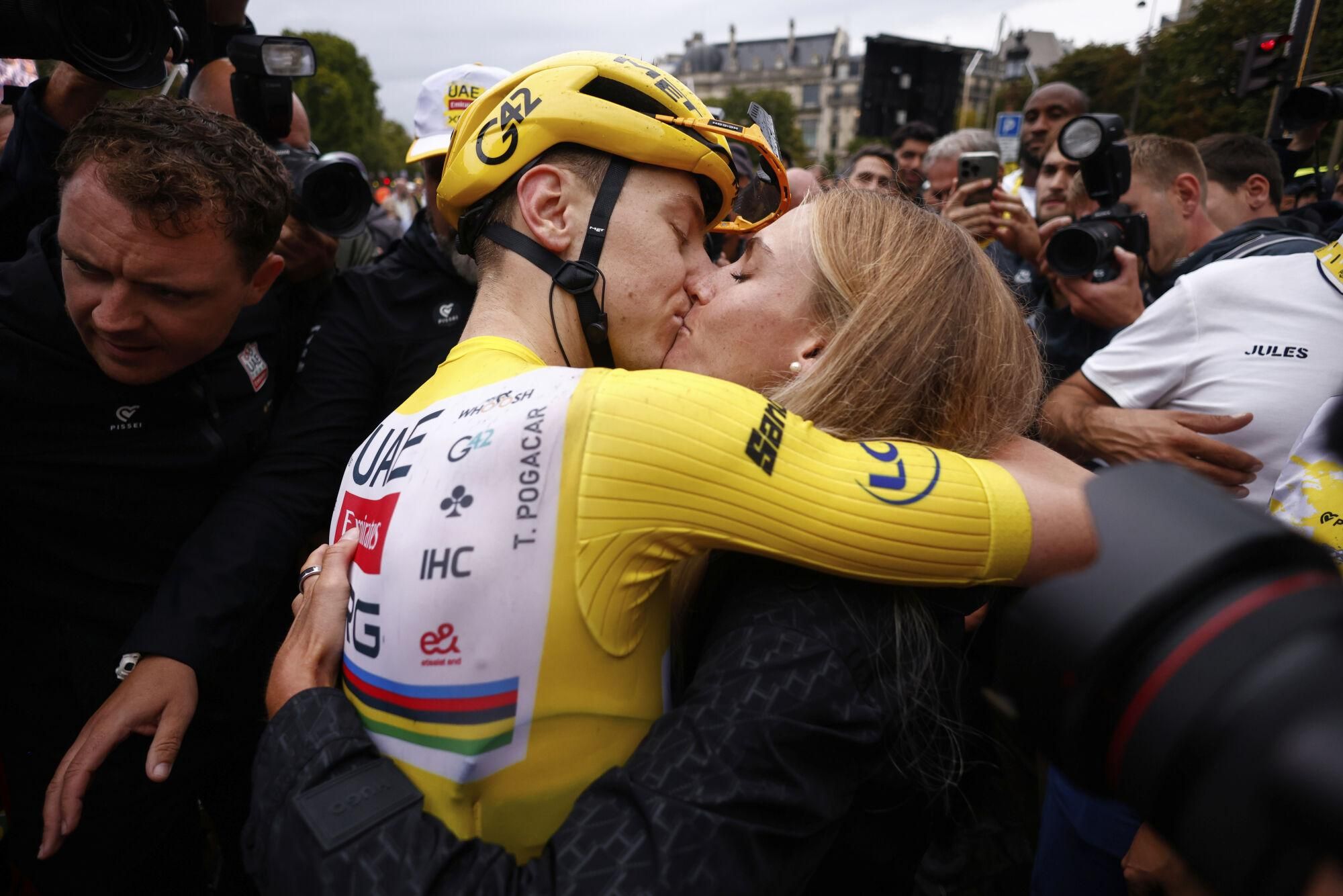 Slovenia's Tadej Pogacar, the Tour de France winner, is greeted by his partner Urska Zigart after finishing, the twenty-first stage of the Tour de France cycling race over 132.3 kilometers (82.1 miles) with start in Mantes-la-Ville and finish on the Champs-Elysees in Paris, France, Sunday, July 27, 2025. (Yoan Valat, Pool Photo via AP). POOL PHOTO