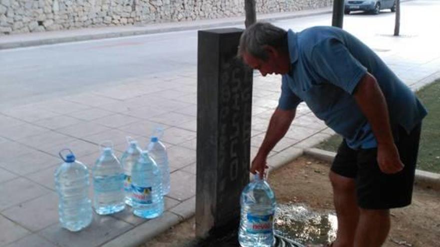 Un vecino de Els Pontets llenando las garrafas de la fuente municipal.