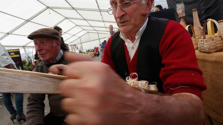 El cestero Vicente Alba, en primer término, con Ángel Fernández, ayer, en la feria de San Isidro.