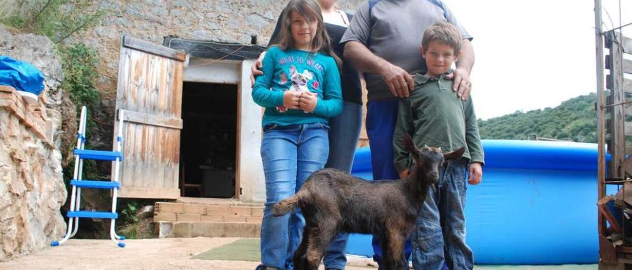 Sigita Stumbraite, Ginés Morales, Alexandra y Pablo, ayer, con una de sus cabras, delante de su casa.