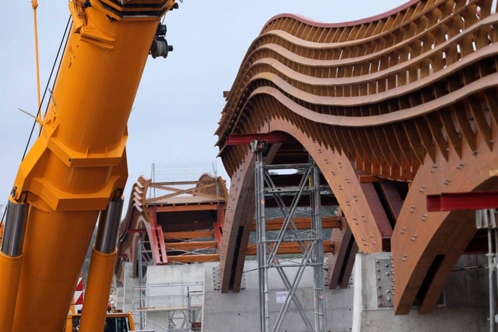 La instalación del último tramo del puente de madera sobre el río Guadalhorce ha comenzado este martes.