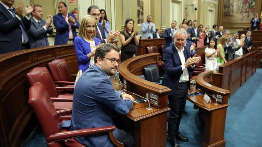 Sobre estas líneas, el Parlamento aplaude a Asier Antona tras ser designado senador en representación de la Comunidad Autónoma; a la derecha, Fernando Clavijo en un instante del pleno.