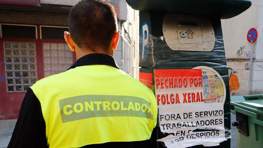 Un controlador en huelga junto a un parquímetro precintado. // Alba Villar